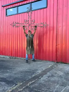 Raúl with the crucifix outside the workshop.