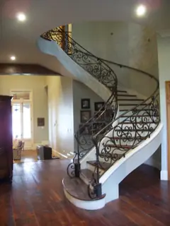 Curved stairs beside tall windows.