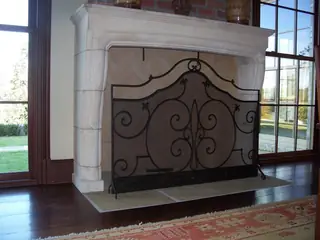 Screen in front of a pale stone fireplace.