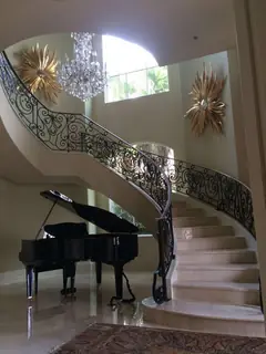 Curved staircase and piano.
