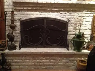 Screen in front of a stone fireplace.
