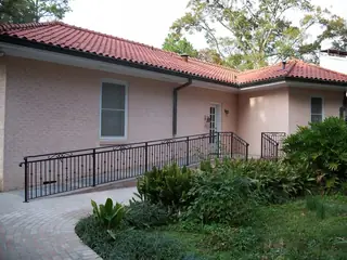 Straight railing beside a ramp.