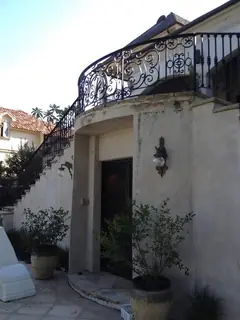 Entrance beneath a curved balcony.