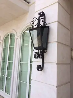 Outdoor lantern beside an arch.