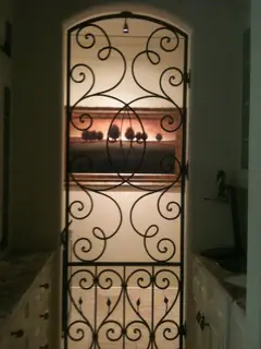 Ornamental grille in front of shelves.