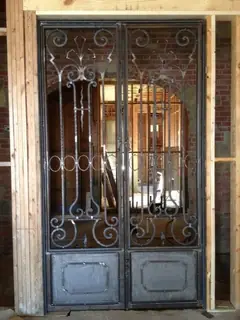 Double doors with glass and scrolls.