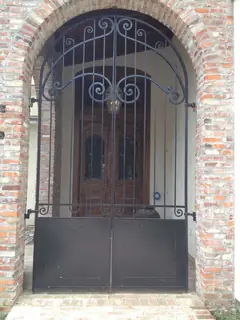 Ironwork door in a brick arch.