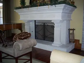 Screen in a fireplace with a pale mantel.