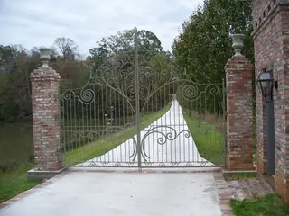 Pale gate at the end of a driveway.