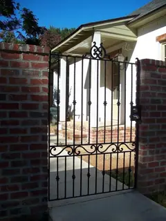 Pedestrian gate between brick pillars.