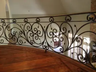 Scrollwork railing beside stairs.