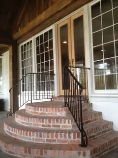 Handrail beside brick steps.