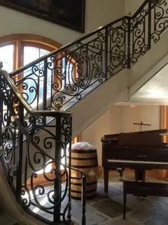 Ornamental staircase beside a piano.