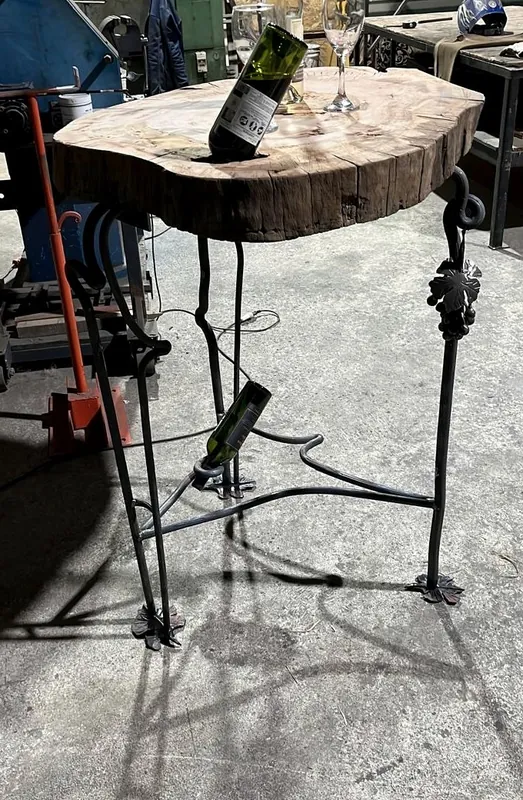 A table with a wood cross-section top and vine-shaped iron legs.